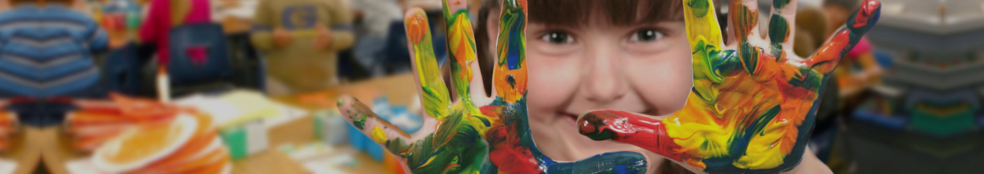 Young School Age Child Painting With Her Hands in Class